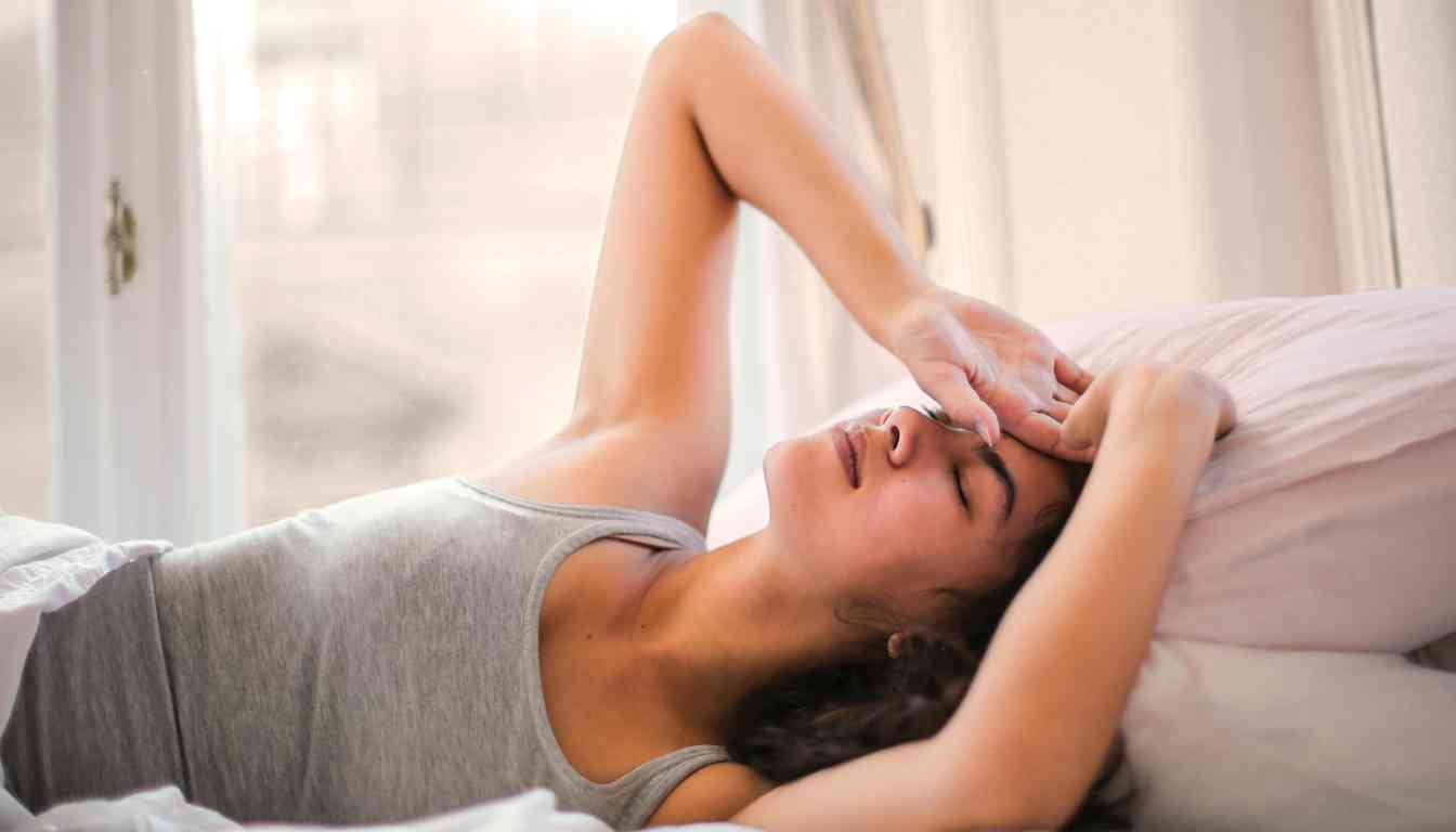 A woman lying in bed, struggling to sleep.