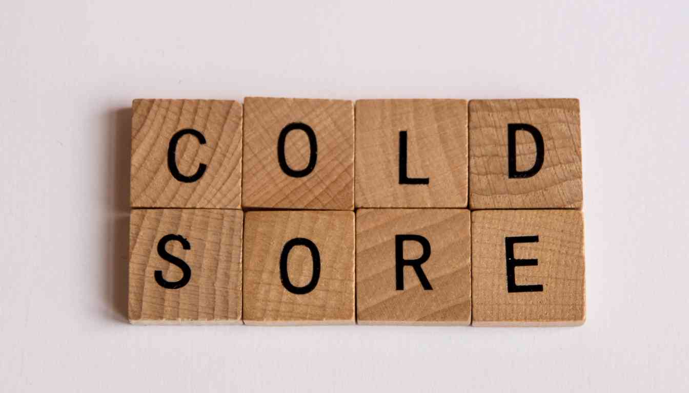 Wooden letter blocks arranged to spell “COLD SORE” on a white surface.