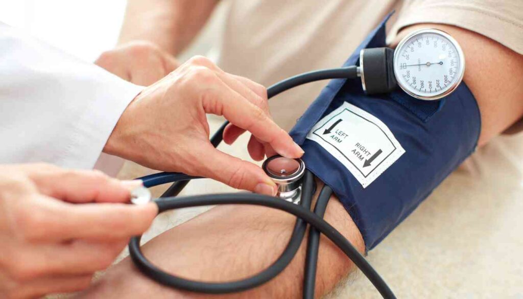 A healthcare professional is measuring a patient’s blood pressure using a sphygmomanometer and stethoscope.