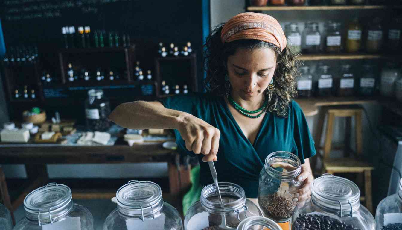 A person in a green shirt and headband is scooping herbs from a jar in a store filled with various jars of herbs and spices.