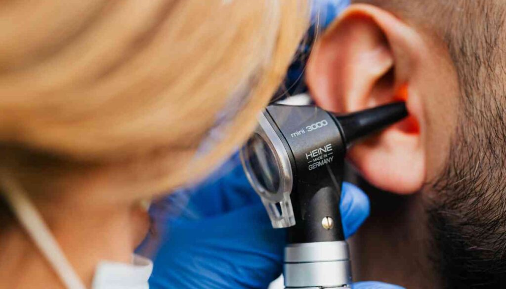 A close-up of a healthcare professional using an otoscope to examine a person's ear.