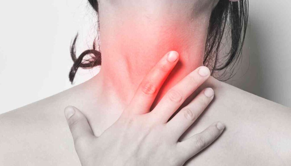 A person touching their throat, which is highlighted in red, indicating pain or discomfort.