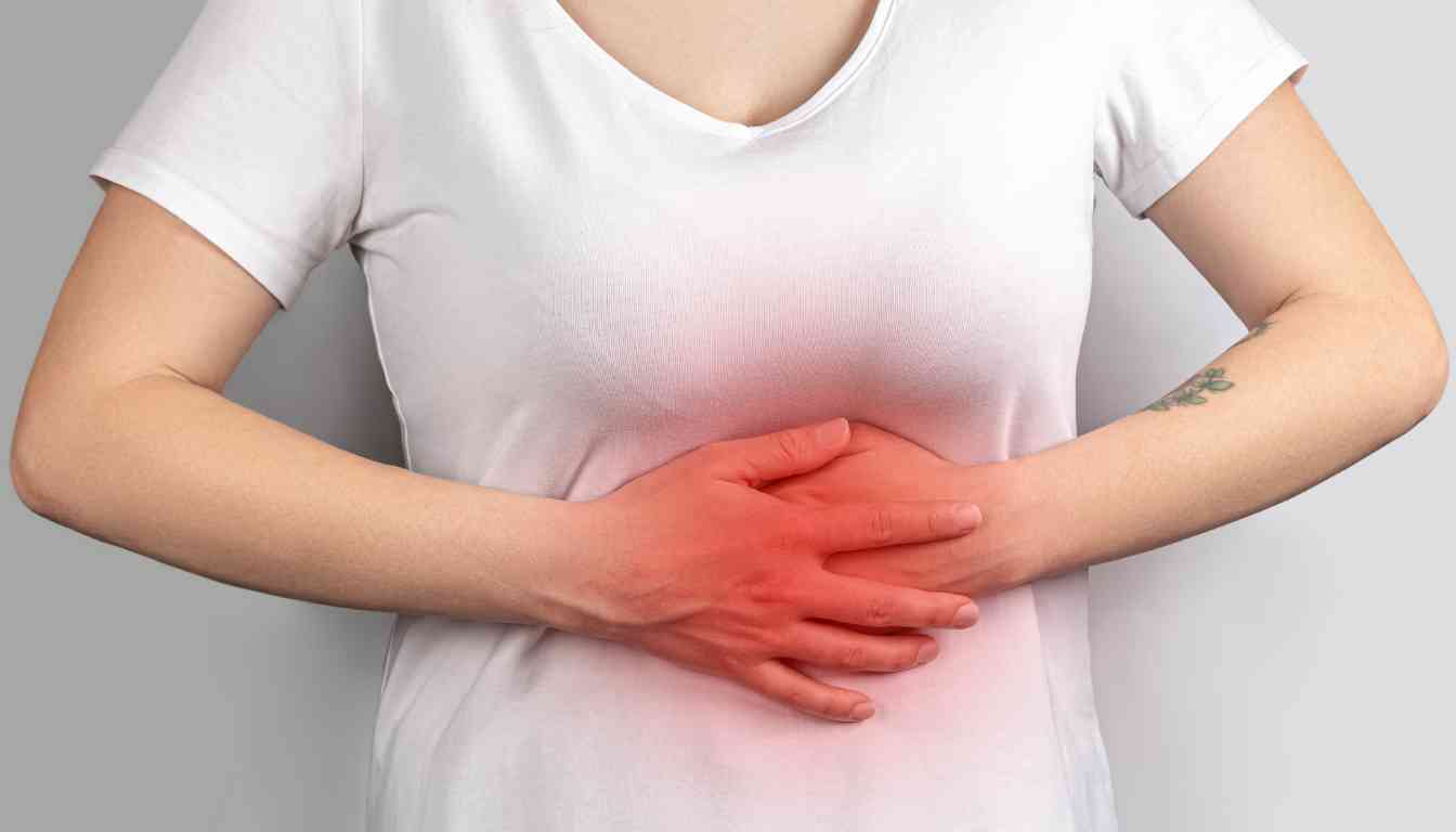 Person holding stomach with both hands, indicating gastric pain.