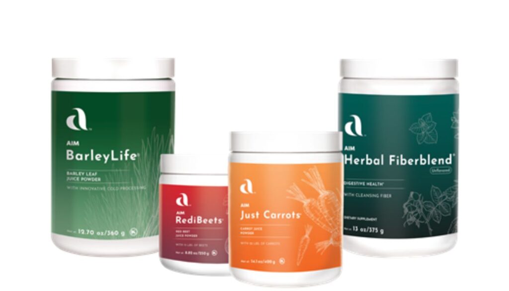 Four AIM dietary supplement containers including Herbal Fiberblend, BarleyLife, RediBeets, and Just Carrots arranged on a table.