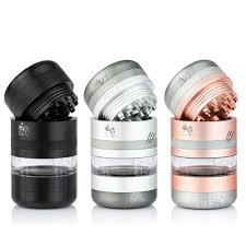 Three herb grinders in black, silver, and rose gold colors, each with a clear middle section and a textured top for grinding.