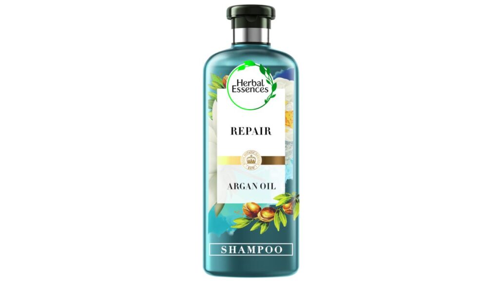 Blue bottle of Herbal Essences Argan Oil Shampoo featuring a green leafy logo, argan nuts, and “Repair” label, designed for damaged hair care.