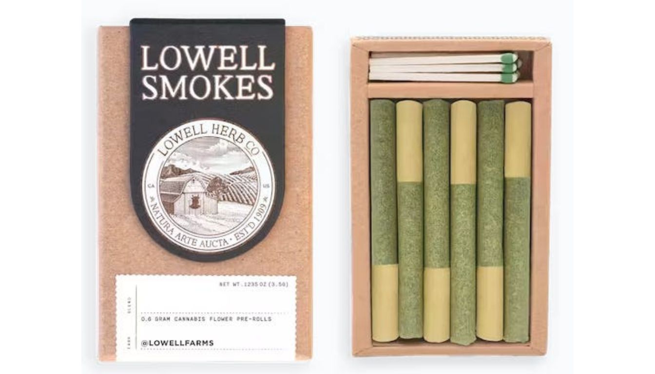 A box of Lowell Smokes cannabis pre-rolls from Lowell Herb Co. The box is open, revealing five green and beige pre-rolled joints and a set of matches.