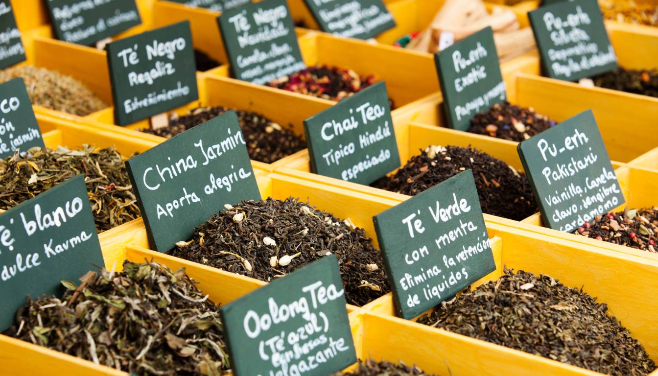 Various types of loose leaf teas displayed in wooden boxes with labels in Spanish.