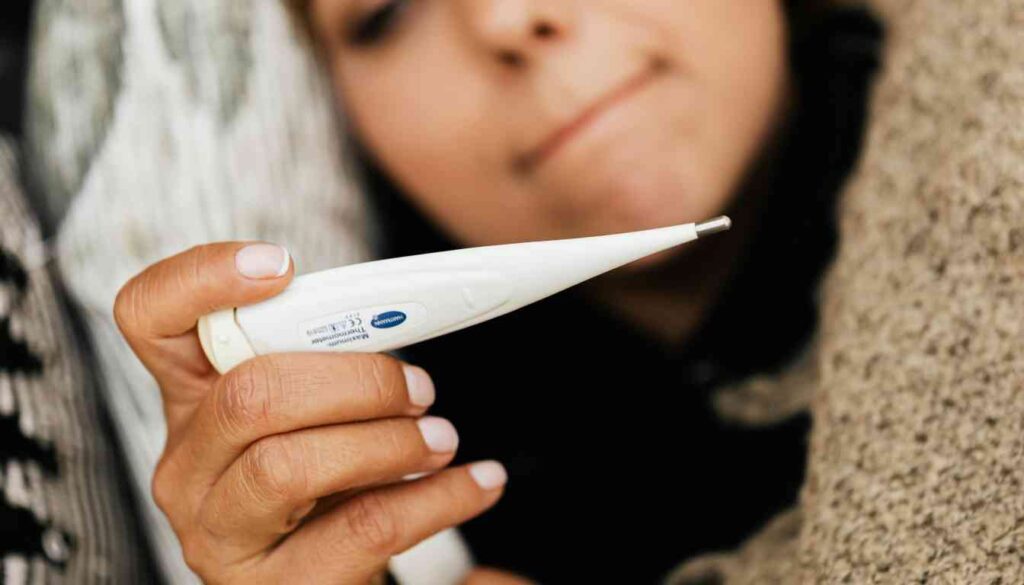 A person holding a digital thermometer.