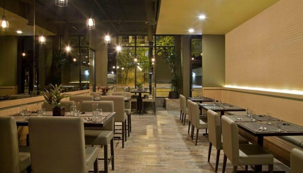 Upscale restaurant interior with beige chairs, warm lighting, and minimalist decor at Herb Chicago.