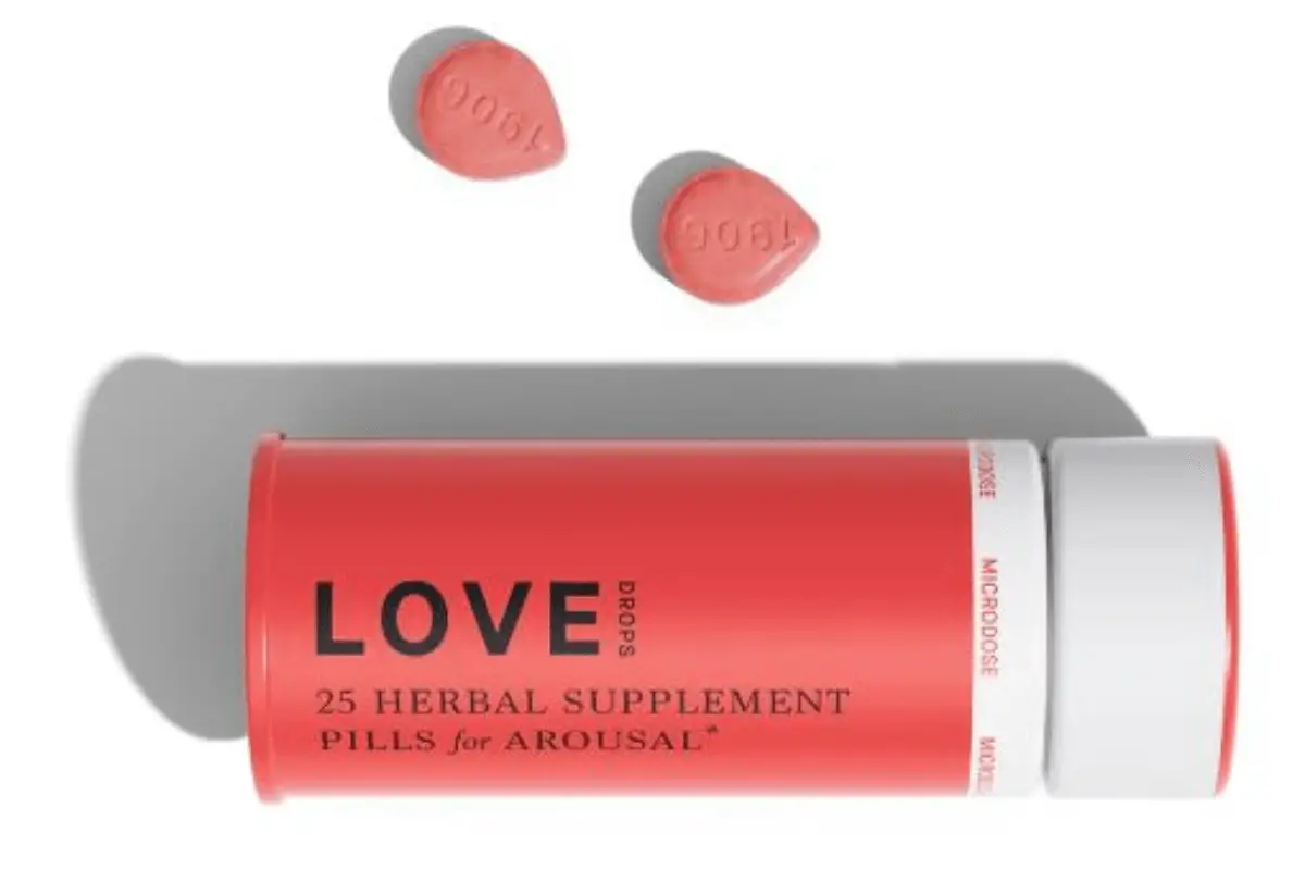 A bottle of Love Drops herbal supplement pills with three pills beside it.