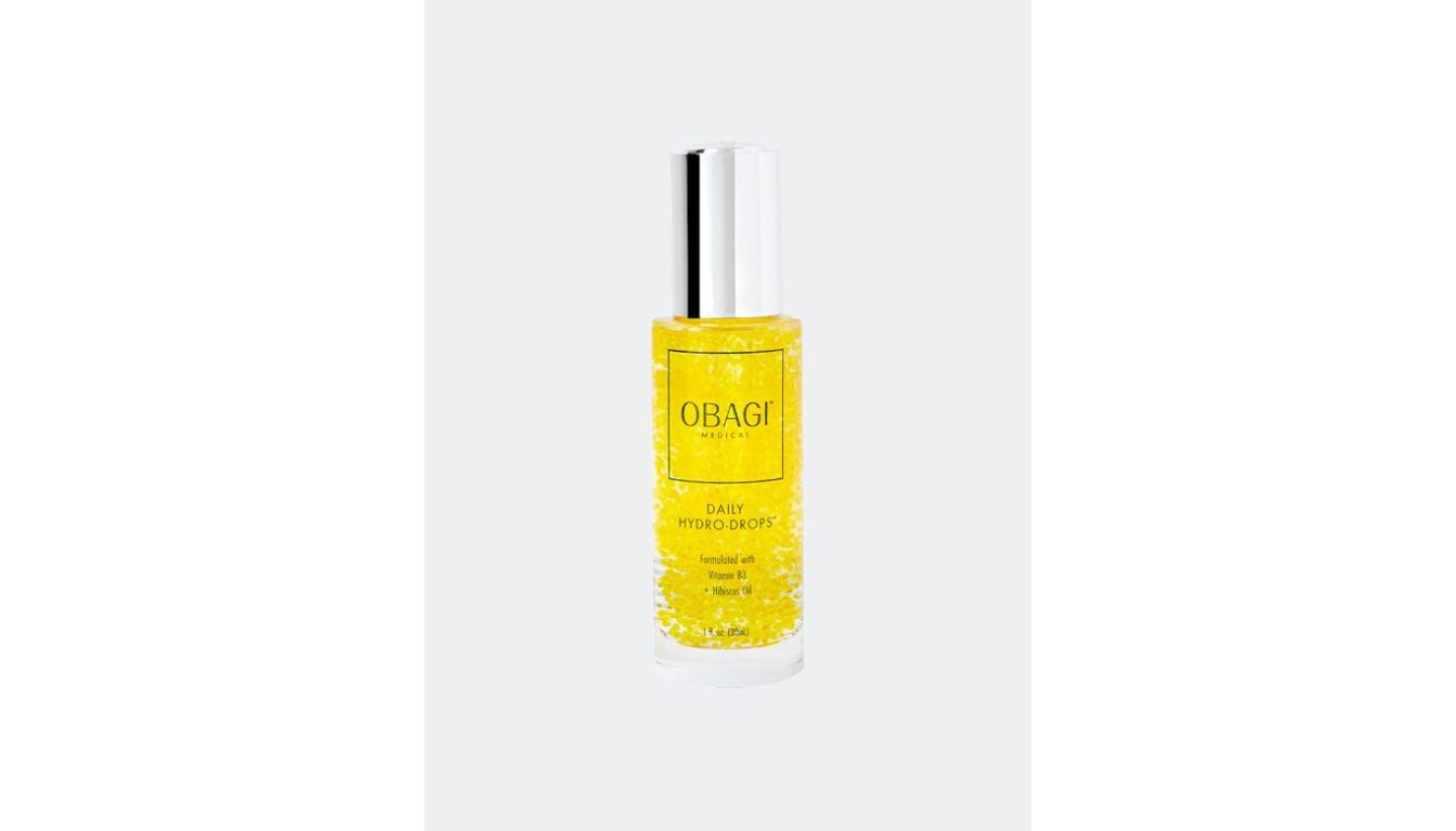 A bottle of Obagi Medical Daily Hydro-Drops, a popular skincare product, with a silver cap and yellow liquid containing visible droplets.