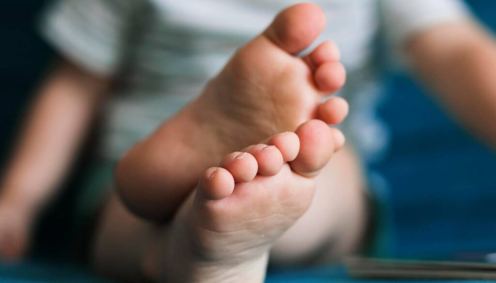 Close-up of a person's feet with a focus on the toes, showing clean and healthy toenails.