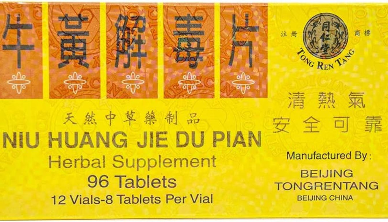 A yellow and orange box of Niu Huang Jie Du Pian herbal supplement tablets, prominently displaying the product name and manufacturer details.