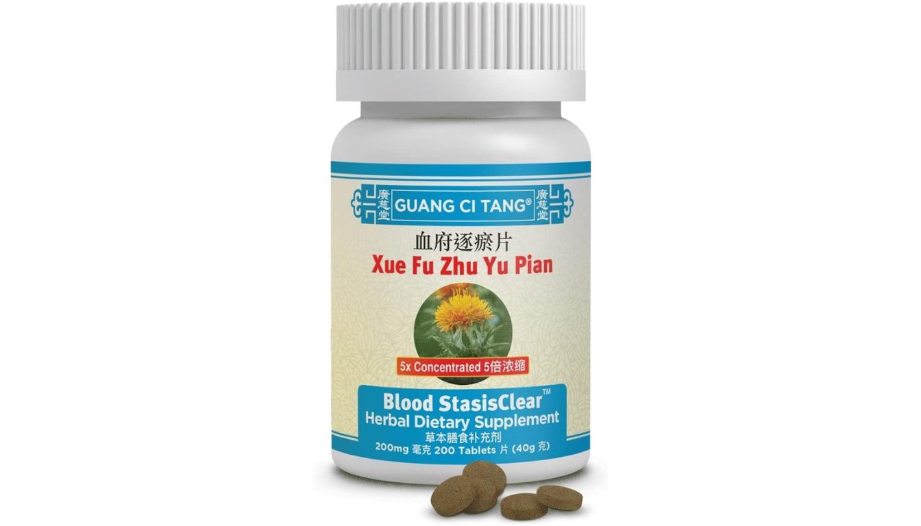 A bottle of Guang Ci Tang Xue Fu Zhu Yu Pian Blood StasisClear Herbal Dietary Supplement with tablets in front of it.