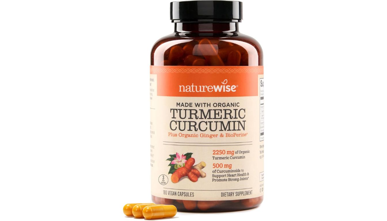 A bottle of NatureWise Curcumin Turmeric dietary supplement with a clean, orange label, featuring 180 vegan capsules for joint and heart support.