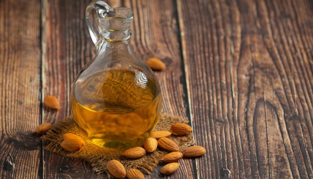A bowl filled with raw almonds, placed on a wooden table alongside a measuring spoon and a keto diet meal plan sheet.