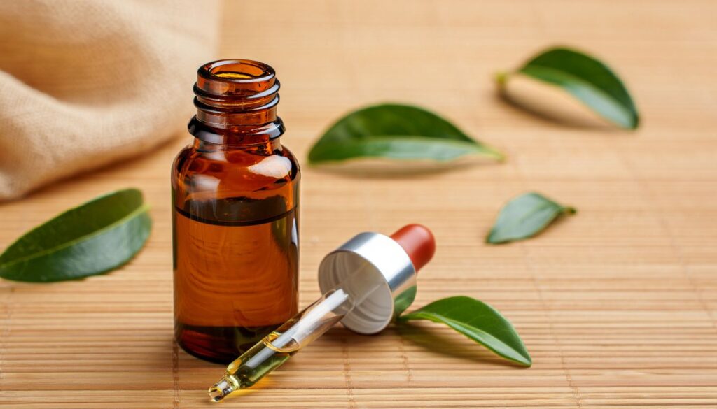 A brown glass bottle with a dropper containing green tea extract, surrounded by fresh green tea leaves on a bamboo mat.