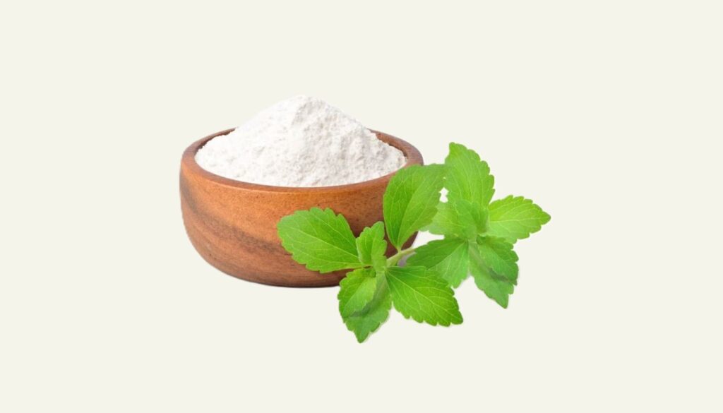 Fresh green stevia leaves alongside a bowl of stevia powder, placed on a wooden table.