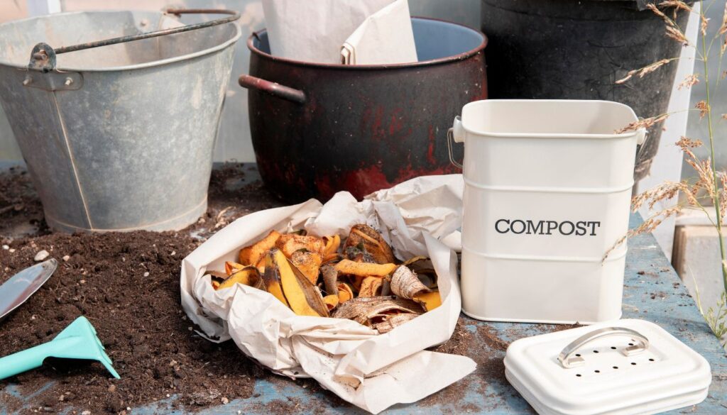 Budget-friendly composting setup showing kitchen scraps, leaves, and recycled containers arranged in a DIY compost bin.