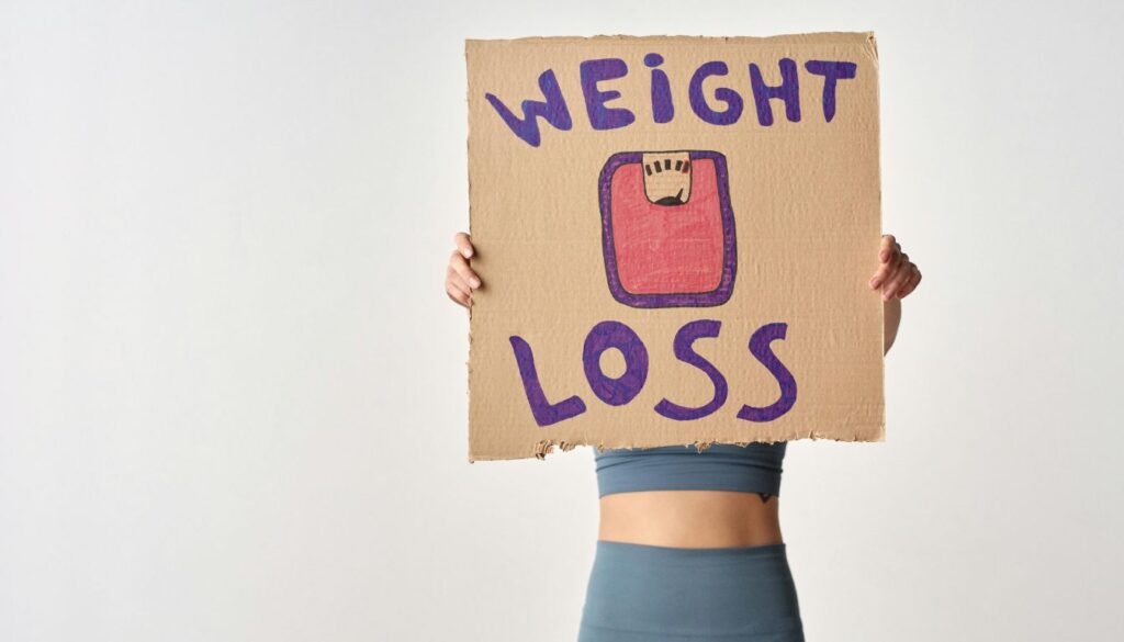 A person holding a card with the words "weight loss".
