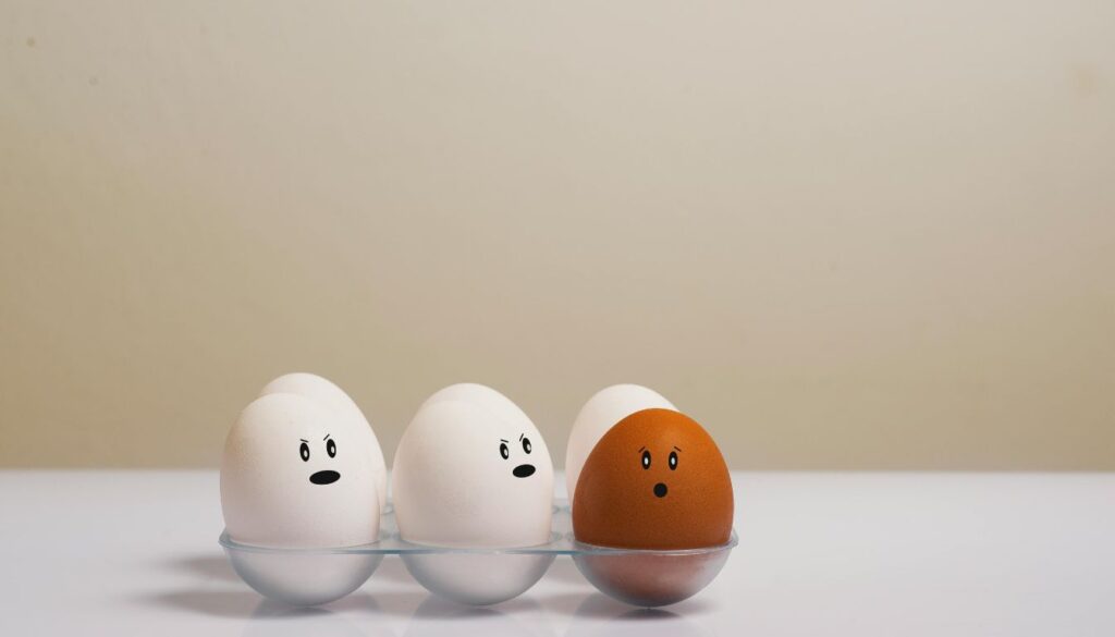 A carton of eggs labeled 'pasteurized' arranged beside a thermometer and water bath diagram.