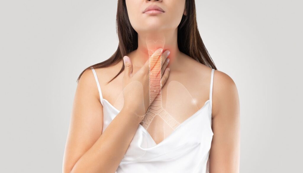 A woman takes a deep breath outdoors, eyes closed, with a serene expression, symbolizing natural asthma relief.