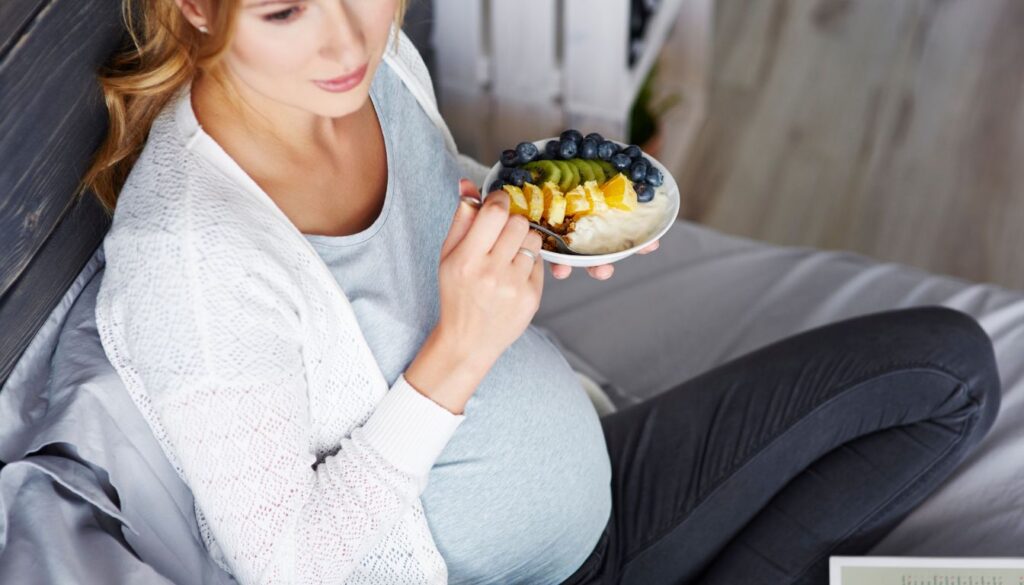 An array of colorful fruits arranged with icons indicating picks and avoids for pregnancy.