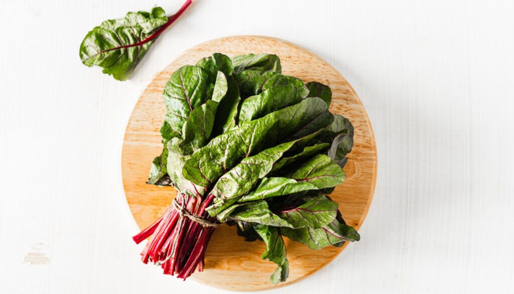 Fresh Swiss chard leaves with vibrant green and colorful stalks, showcasing their rich texture and nutritional value.