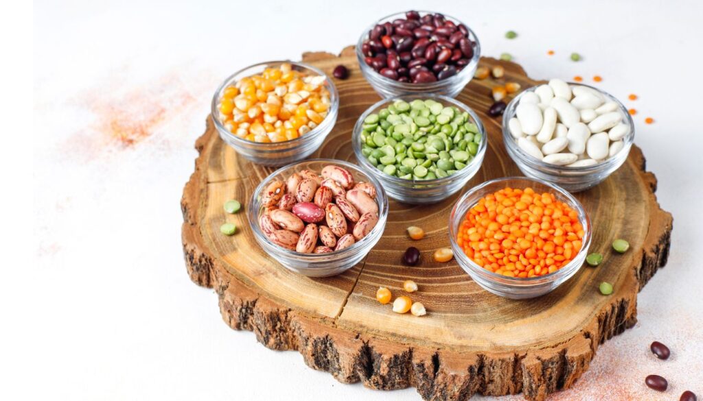 A selection of nutritious foods rich in phytic acid, including nuts, seeds, legumes, and whole grains, arranged on a wooden surface.