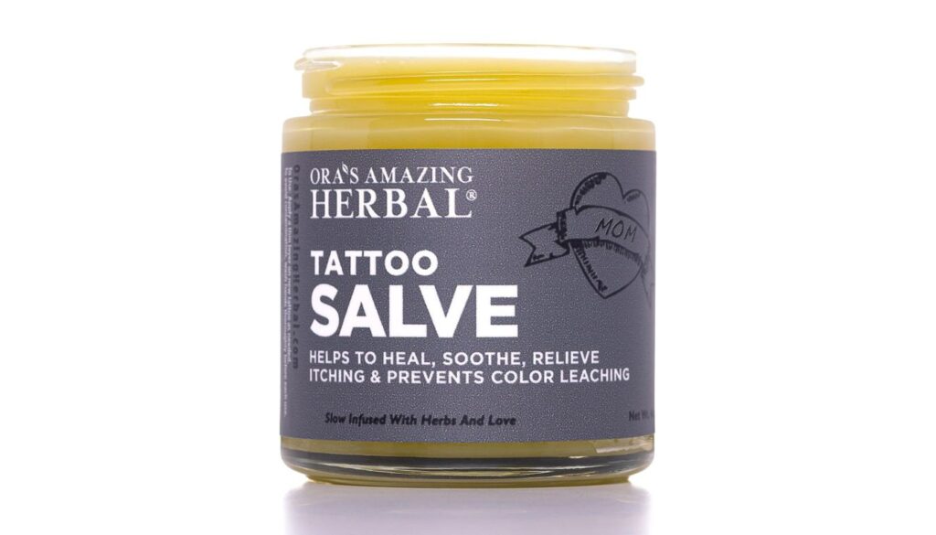 Jar of Ora's Amazing Herbal Tattoo Salve with dark label and heart-shaped tattoo design.